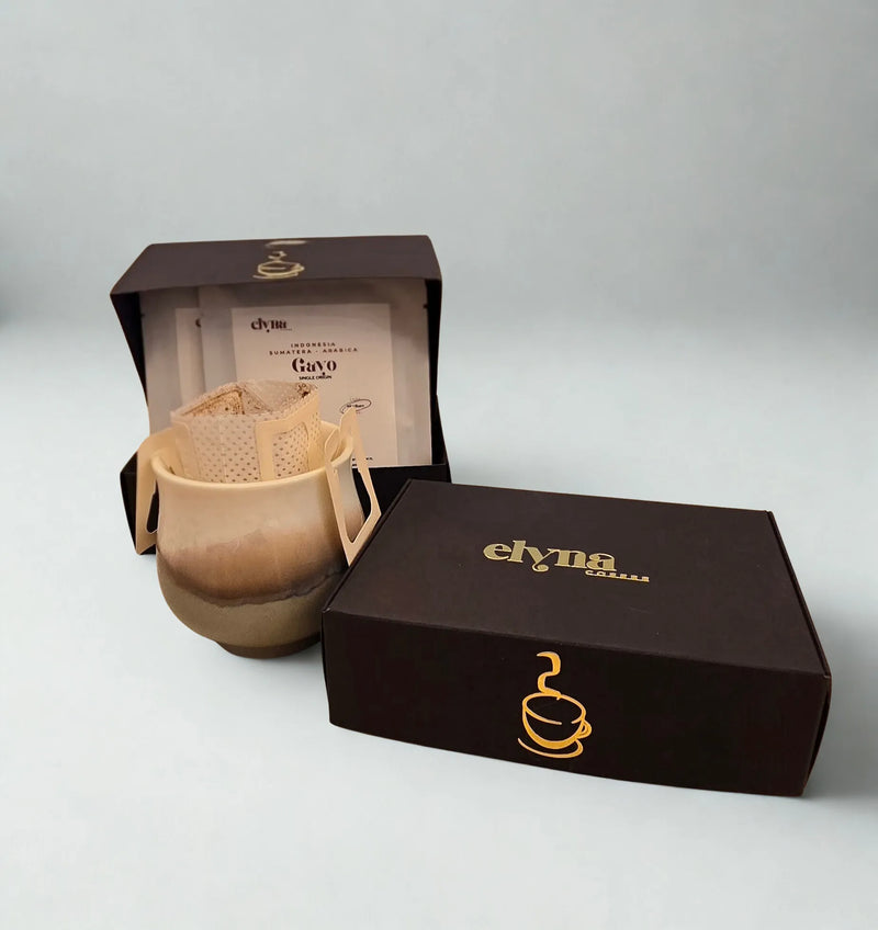 Ceramic mug with filter and Elyna branded box on a gray background