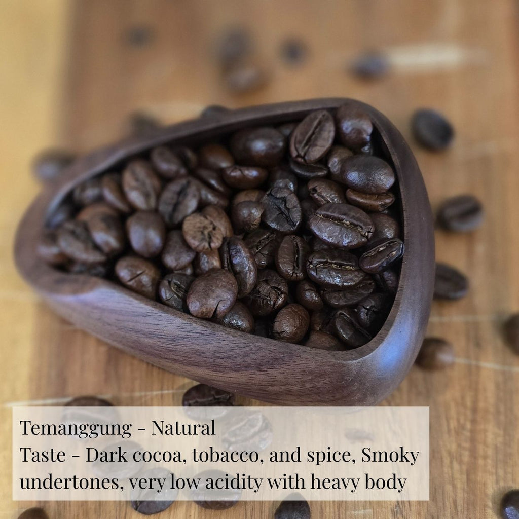 Wooden scoop filled with coffee beans on a wooden surface with text describing the coffee's taste profile.