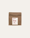 Brown coffee packaging with a white label on a beige background