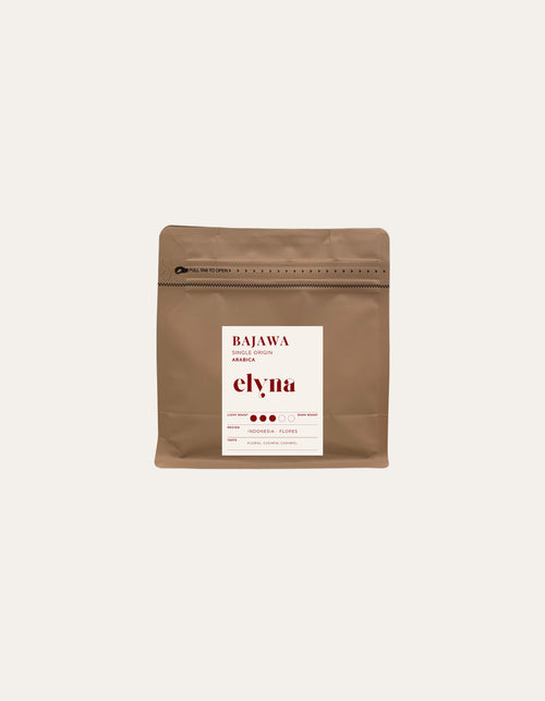 Brown coffee packaging with a white label on a beige background