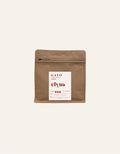 Brown coffee packaging with a white label on a beige background