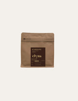 Brown coffee packaging with 'elvia' branding on a beige background