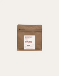 Brown coffee packaging with a white label on a beige background