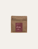 Brown coffee packaging with a red label on a beige background